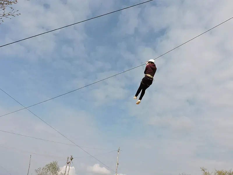 Gost na dolinskoj zipline iznad šume u Glavani Parku, Istria